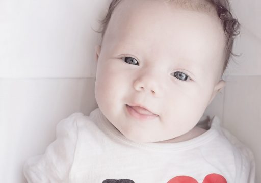 Baby liggend op een witte achtergrond, klaar voor een officiële pasfoto