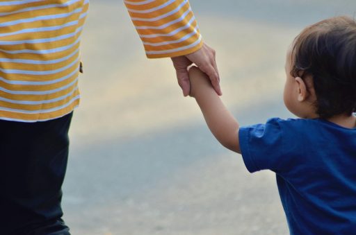 Ouder leest voor aan kind op de bank met een boek op schoot