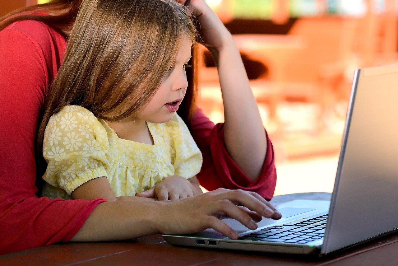 Ouder in gesprek met kind aan de keukentafel, rustige sfeer thuis