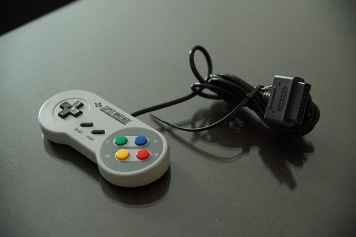 Kind speelt op een spelcomputer in de woonkamer, terwijl een ouder meekijkt