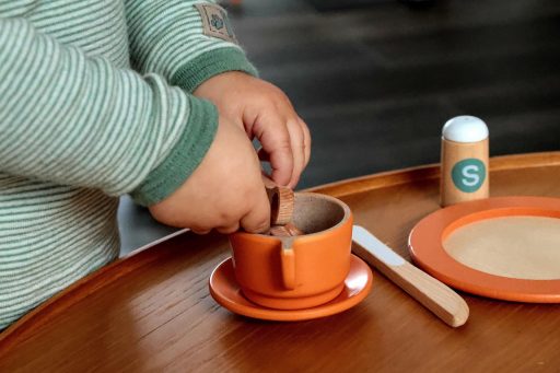 Ouder inspecteert tweedehands houten speelgoed op veiligheid