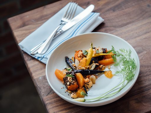 Kind aan tafel kijkt naar een bord met peulvruchten