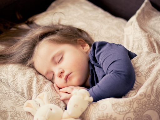 Kind dat woelt in bed tijdens een warme zomernacht