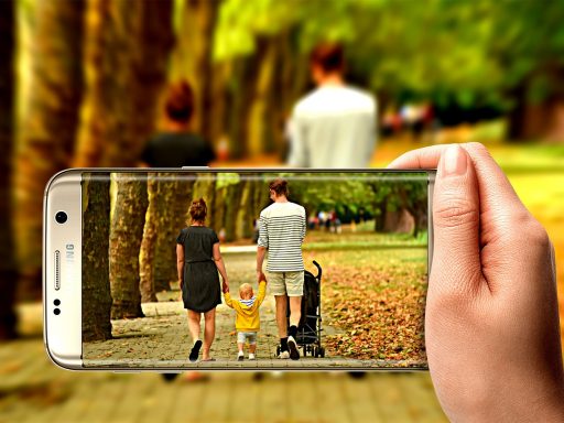 Kind houdt een smartphone vast buiten op een zonnige dag