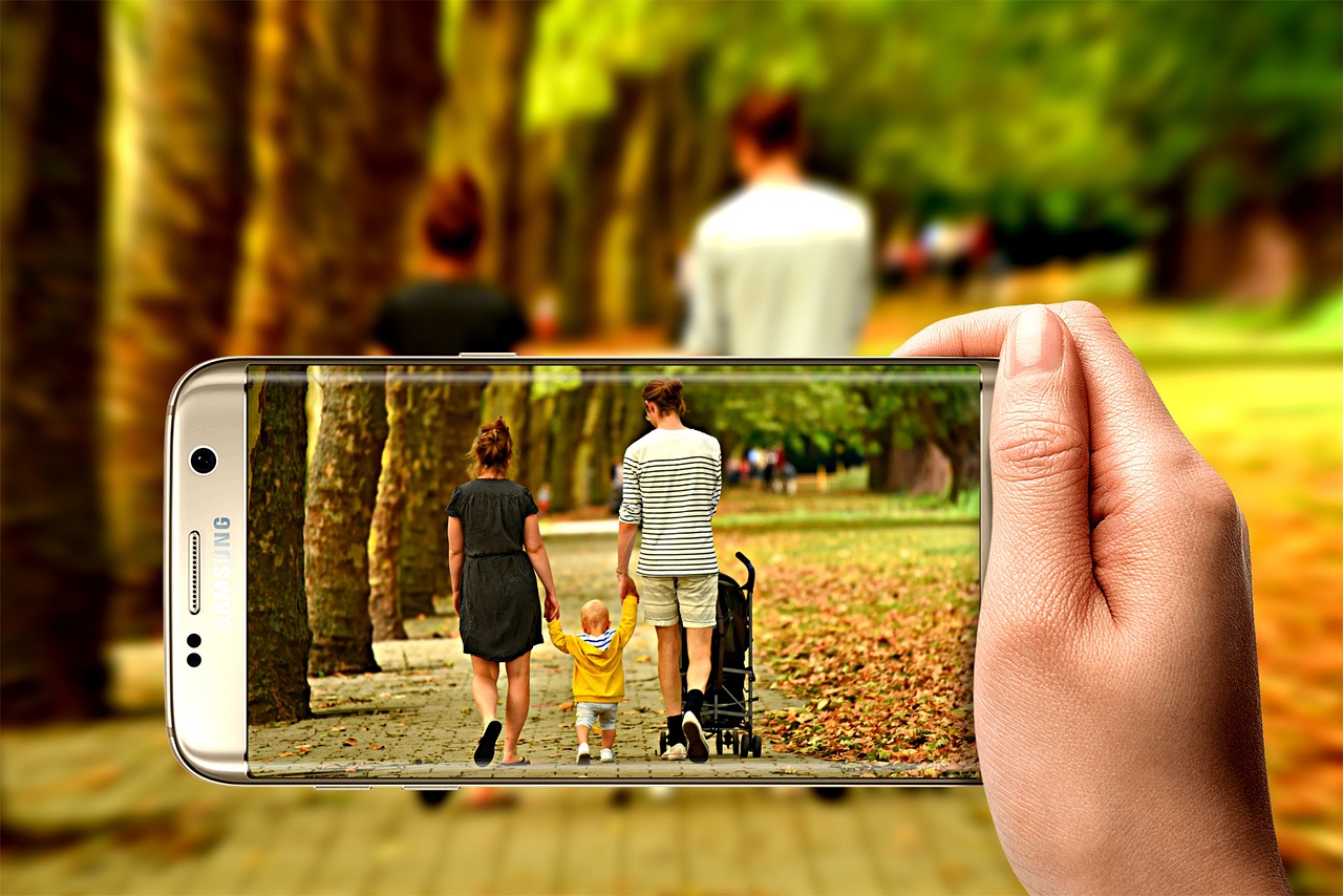 Kind houdt een smartphone vast buiten op een zonnige dag