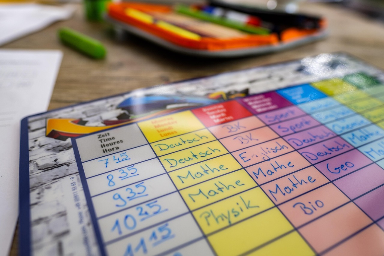 Een kind dat twijfelend voor zijn huiswerk zit en de pen vasthoudt zonder te schrijven