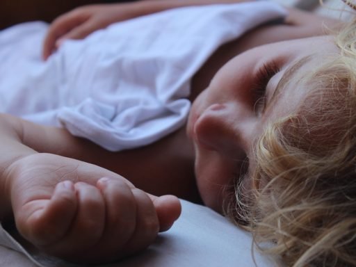 Jong kind slaapt rustig in bed met een knuffel