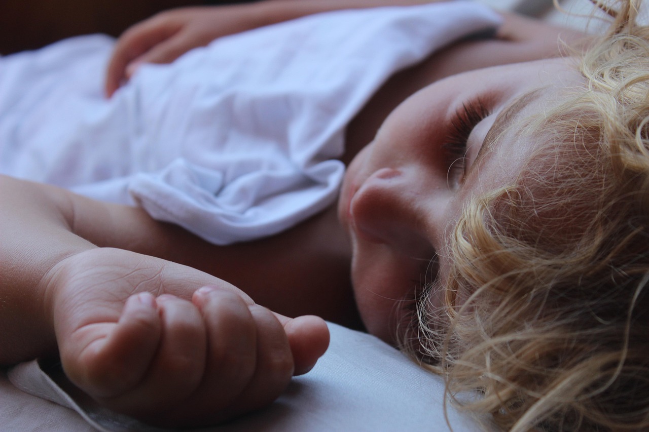 Jong kind slaapt rustig in bed met een knuffel