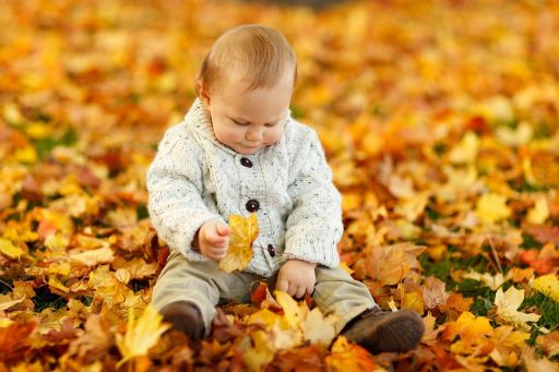 Kind speelt buiten op een bewolkte herfstdag in de tuin