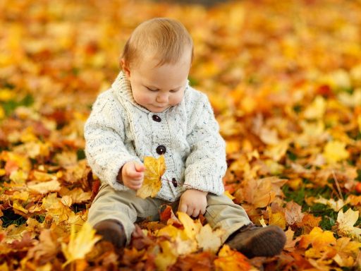Kind speelt buiten op een bewolkte herfstdag in de tuin