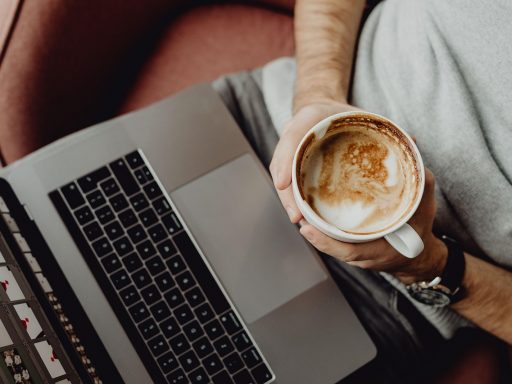 Kind dat thuis op een laptop surft terwijl een ouder meekijkt