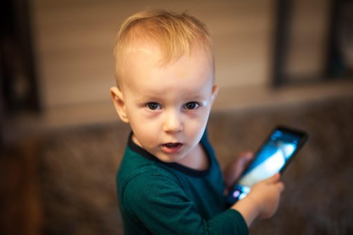 Kind dat een smartphone vasthoudt terwijl een locatiemelding op het scherm verschijnt